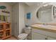 Cozy bathroom featuring a white vanity with tiled counter, round mirror and beach themed decorations at 11839 Saddleback Ct, Parker, CO 80138