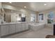 Large primary bathroom with double vanity sinks and soaking tub nestled near a window at 11839 Saddleback Ct, Parker, CO 80138