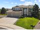 A stately two-story home with a three car garage, manicured lawn, and stone accents on the facade at 11839 Saddleback Ct, Parker, CO 80138