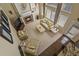 Aerial view of open living room with fireplace and tall windows adjoining kitchen with breakfast bar seating at 11839 Saddleback Ct, Parker, CO 80138