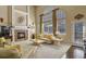 Bright living room with a fireplace, tall windows, and plush seating offers a cozy and inviting atmosphere at 11839 Saddleback Ct, Parker, CO 80138