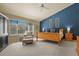 Inviting bedroom with blue accent wall, cozy chair by window, and warm wood furniture at 11839 Saddleback Ct, Parker, CO 80138