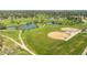 Aerial view of a community park featuring a baseball field, pond, walking path, and green spaces at 707 Uvalda St, Aurora, CO 80011