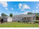 Exterior shot of a home's backyard featuring a grassy lawn, a shed, and a covered patio area at 707 Uvalda St, Aurora, CO 80011