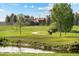 Scenic walking path in a community park with lush greenery and a pond at 707 Uvalda St, Aurora, CO 80011