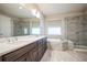 Luxurious bathroom featuring dual sinks, a soaking tub, and a glass-enclosed shower at 14221 Ivanhoe St, Thornton, CO 80602