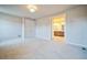 Spacious bedroom with neutral tones and a view into the well-lit bathroom at 14221 Ivanhoe St, Thornton, CO 80602