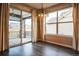 Bright dining area with wood floors, modern light fixture, sliding glass doors to outdoor patio, and large picture window at 14221 Ivanhoe St, Thornton, CO 80602