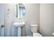 Cozy half bathroom featuring a pedestal sink, oval mirror, and modern fixtures at 14221 Ivanhoe St, Thornton, CO 80602
