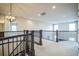 Upstairs hallway with modern light fixtures and staircase to lower level at 14221 Ivanhoe St, Thornton, CO 80602