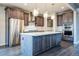 Gourmet kitchen featuring a large island, stainless steel appliances, and designer lighting at 14221 Ivanhoe St, Thornton, CO 80602