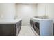Functional laundry room with modern washer and dryer, sink, and ample counter space at 14221 Ivanhoe St, Thornton, CO 80602
