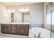 Bright main bathroom with double sinks, soaking tub, separate shower, and large mirror at 14221 Ivanhoe St, Thornton, CO 80602