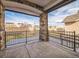 Covered patio with stone pillars and black metal railing offers an inviting outdoor space at 14221 Ivanhoe St, Thornton, CO 80602