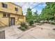 View of the yellow building with a backyard featuring a concrete patio and garden area at 7 Elati St, Denver, CO 80223