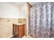 Bathroom featuring a wooden vanity with stone counter and patterned shower curtain at 7 Elati St, Denver, CO 80223