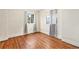 Bedroom featuring hardwood floors, white walls, and large windows with backyard views at 7 Elati St, Denver, CO 80223