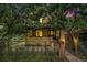Charming two-story yellow home featuring a covered porch, mature trees, and fenced front yard at 7 Elati St, Denver, CO 80223