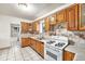 Functional kitchen with wood cabinetry, a gas stove, and decorative tile backsplash at 7 Elati St, Denver, CO 80223