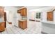 Charming kitchen with wood cabinets, a white refrigerator, and decorative tile flooring at 7 Elati St, Denver, CO 80223