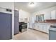 Kitchen with white cabinets, stainless steel appliances, tile floor, and brick accent wall at 7 Elati St, Denver, CO 80223