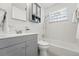 Bathroom featuring a gray vanity, neutral tile, and a glass block window at 2975 S Jackson St, Denver, CO 80210