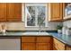 Bright kitchen featuring wood cabinets, green countertops, and a large window overlooking the backyard at 2975 S Jackson St, Denver, CO 80210