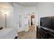 Cozy bedroom with neutral carpet, bright white walls, and a view into the kitchen at 5723 N Gibralter Way # 205, Aurora, CO 80019