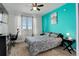 Bedroom featuring vibrant turquoise wall with contrasting black furniture and ceiling fan at 5723 N Gibralter Way # 205, Aurora, CO 80019