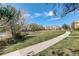 Well-manicured community lawn with mature trees and a sidewalk running through the grassy space at 5723 N Gibralter Way # 205, Aurora, CO 80019