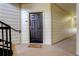 Apartment entrance featuring a black door with a welcome mat and stair access at 5723 N Gibralter Way # 205, Aurora, CO 80019