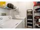 Laundry room with a washer, dryer, storage shelves, and a ladder at 5723 N Gibralter Way # 205, Aurora, CO 80019