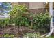 A well-maintained backyard with lush greenery, flowering shrubs, and a black iron fence at 6917 E Girard Ave, Denver, CO 80224