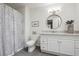 Well-lit bathroom featuring white vanity, round mirror, tile flooring, and a shower with curtain at 6917 E Girard Ave, Denver, CO 80224