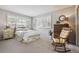 Bright bedroom with neutral walls, a patterned bedspread, and shuttered windows for natural light at 6917 E Girard Ave, Denver, CO 80224