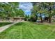 Beautiful clubhouse with manicured lawn, a walkway and mature trees at 6917 E Girard Ave, Denver, CO 80224