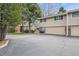 Townhome exterior boasts an attached garage, a well-kept lawn, and mature trees in a friendly neighborhood at 6917 E Girard Ave, Denver, CO 80224