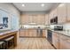 Open kitchen with wooden cabinetry, granite countertops, stainless appliances, and eat-in breakfast bar at 6917 E Girard Ave, Denver, CO 80224