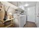 A functional laundry room featuring a washer, dryer, storage cabinets, and ample counter space at 6917 E Girard Ave, Denver, CO 80224