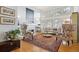Sunlit living room showcasing hardwood floors, tall windows with shutters, and a cozy fireplace with built-in shelves at 6917 E Girard Ave, Denver, CO 80224