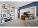 Comfortable living room with a built-in bookcase, blue accent wall, and comfortable seating at 6917 E Girard Ave, Denver, CO 80224