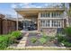 Charming outdoor patio with a dining set, landscaping, and a brick building exterior at 6917 E Girard Ave, Denver, CO 80224