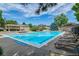 Large rectangular pool with several lounge chairs, surrounded by mature trees and landscaping at 6917 E Girard Ave, Denver, CO 80224