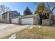 Gray townhouse exterior with two-car garage and landscaped yard at 7165 S Vine W Cir, Centennial, CO 80122