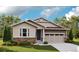 Charming single-story home showcasing a stone facade and an attached two car garage, all surrounded by a lush green lawn at 1363 Lumber Ridge S Cir, Erie, CO 80516
