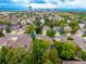 Sprawling aerial view of a residential neighborhood, showcasing homes with lush trees and city views in the distance at 9552 E Caley Cir, Englewood, CO 80111