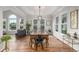 Bright dining room with hardwood floors, tray ceiling, large windows, and an elegant light fixture at 9552 E Caley Cir, Englewood, CO 80111
