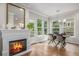 Bright dining room featuring hardwood floors, a fireplace, and large windows with backyard views at 9552 E Caley Cir, Englewood, CO 80111