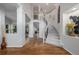 Bright foyer featuring hardwood floors, high ceilings, a curved staircase, and modern chandelier at 9552 E Caley Cir, Englewood, CO 80111