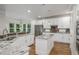 Modern kitchen with white cabinets, granite countertops, stainless steel appliances, and hardwood floors at 9552 E Caley Cir, Englewood, CO 80111